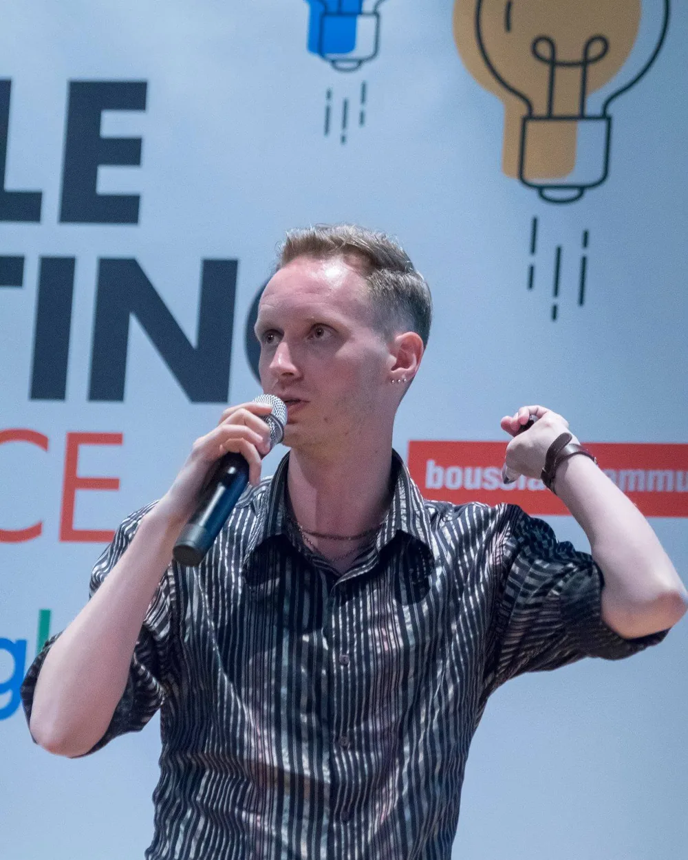 Philip Zeplin speaking with a microphone, gesturing with both hands.
