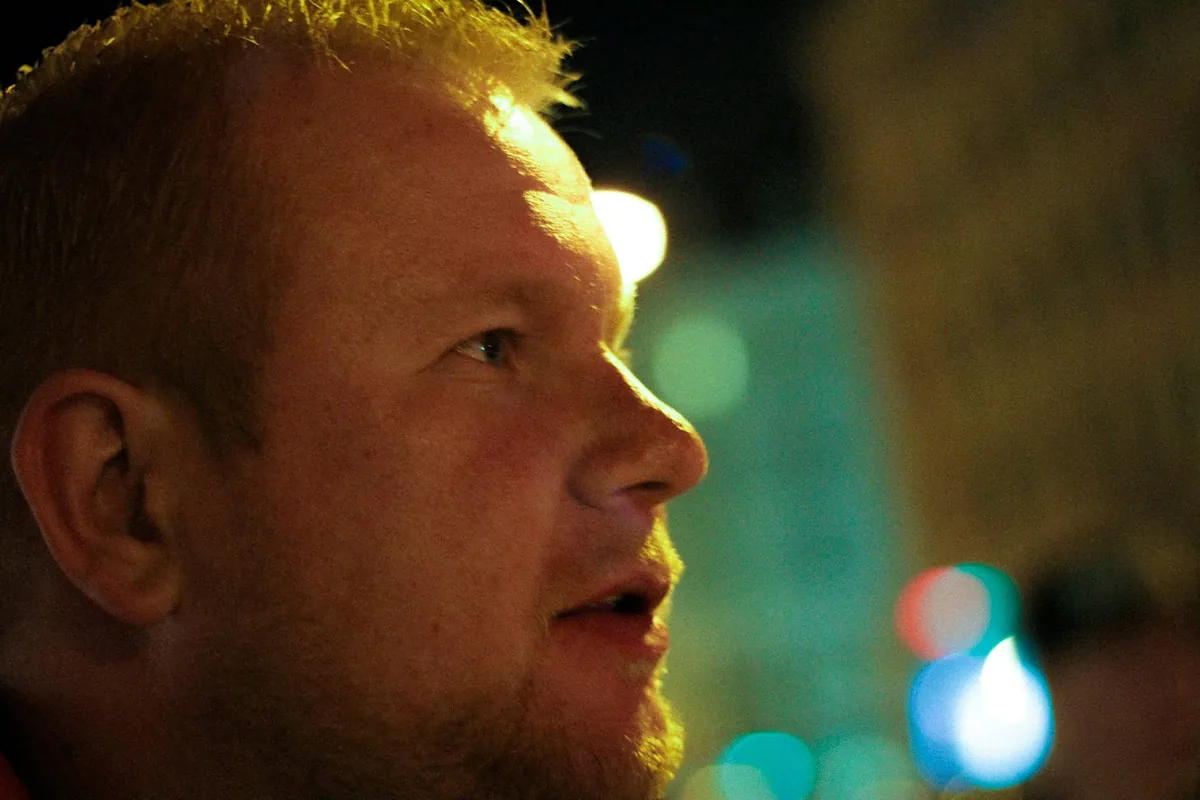 A close profile portrait lit by green and amber lights in Copenhagen.